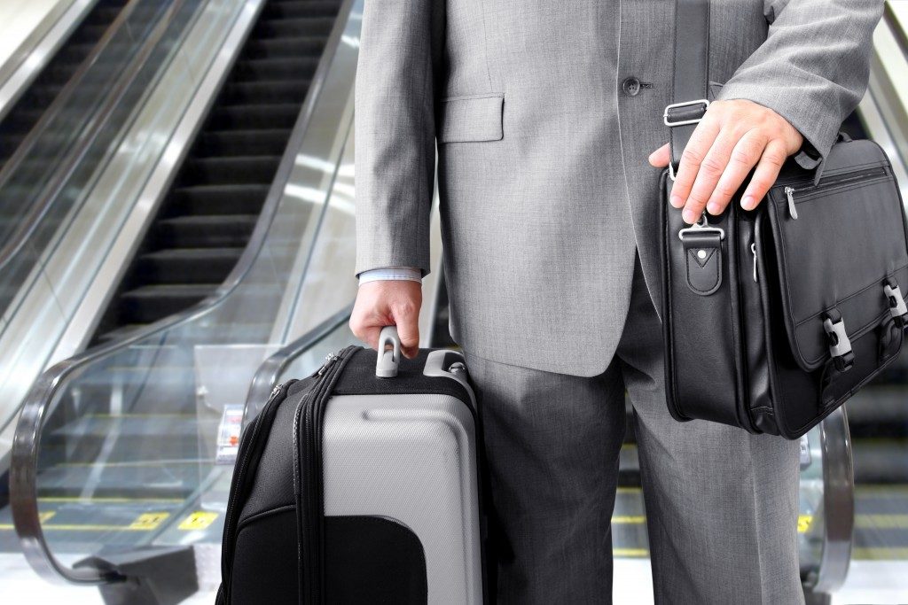 Travelling Businessman. Businessman with his luggage near an escalator at an airport